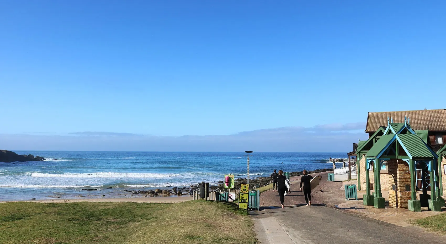 Eine malerische Küstenstadt an der Garden Route im Frühling, umgeben von blühenden Pflanzen und sanften Hügeln
