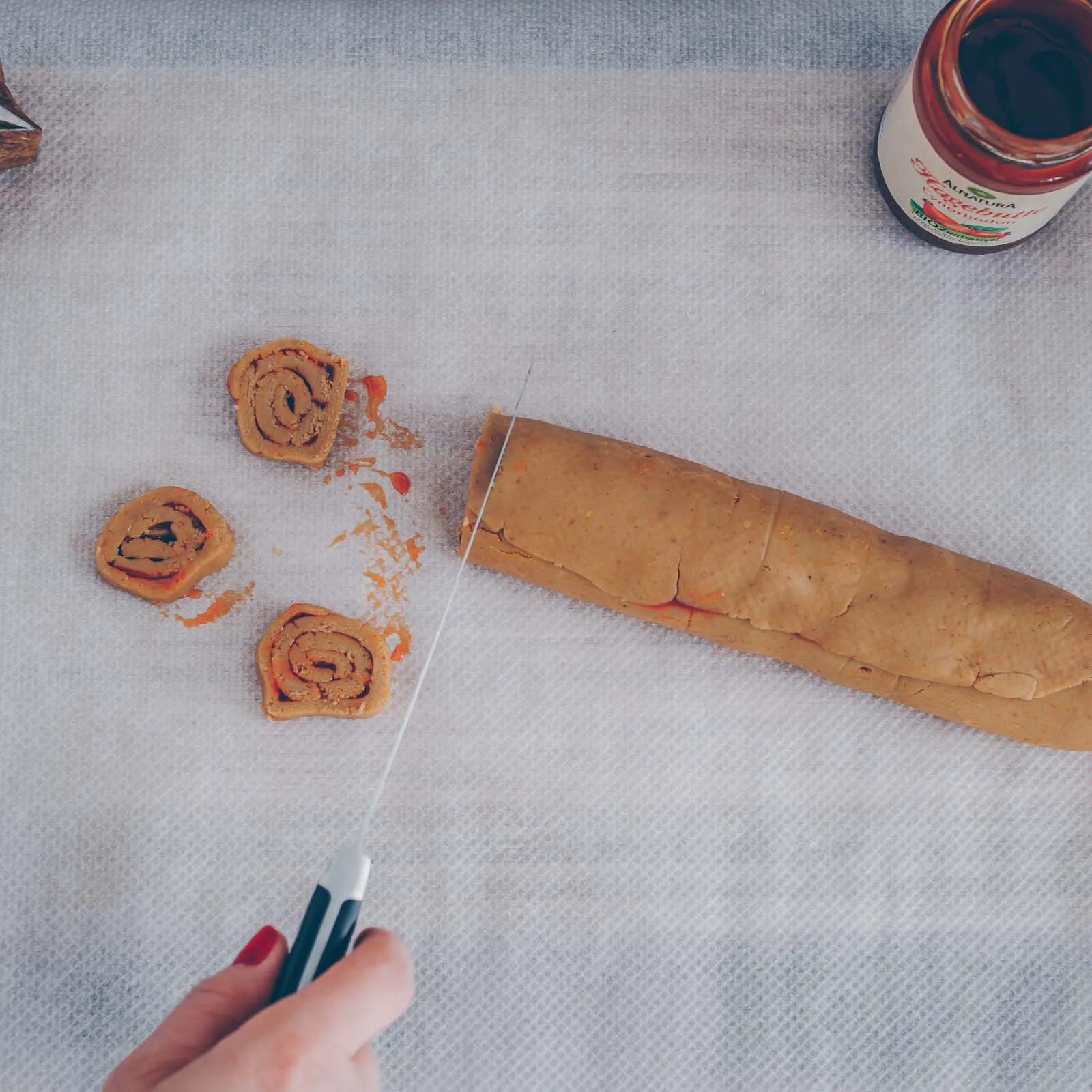 Eine Nahaufnahme von mehreren, perfekt gebackenen veganen Marmeladen-Plätzchen, die die goldene Farbe und Füllung hervorhebt