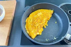 Eine Omelett-Hälfte über die andere schlagen und auf einen Teller geben, um es zu servieren.