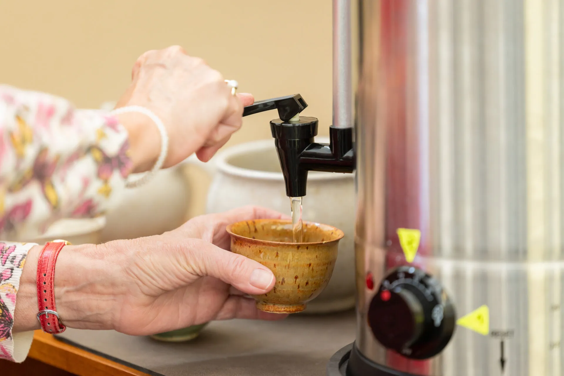 Eine Person gießt sich Tee ein, symbolisch für die Vielfalt der Trinkgewohnheiten in Deutschland.
