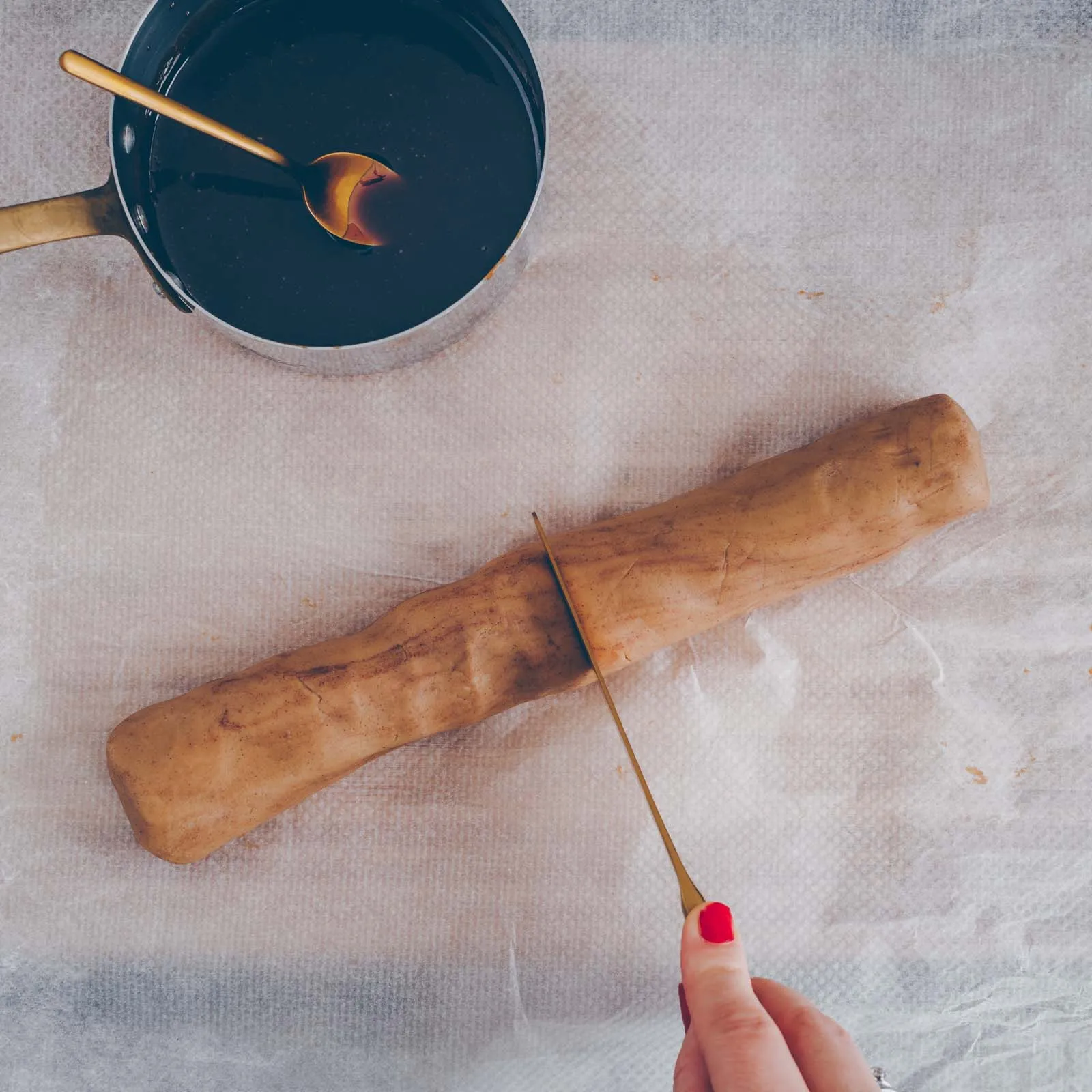 Eine Reihe von rohen Karamell-Thumbprint Cookies, die jeweils mit flüssigem Karamell gefüllt werden