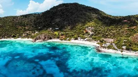 Eine ruhige Bucht von Saint John auf den Amerikanischen Jungferninseln in der Karibik, mit Booten, üppigen Hügeln und klarem Wasser.