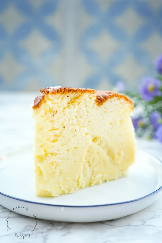 Eine Scheibe des unwiderstehlich leichten japanischen Käsekuchens, die seine souffléartige Konsistenz und Zartheit demonstriert.