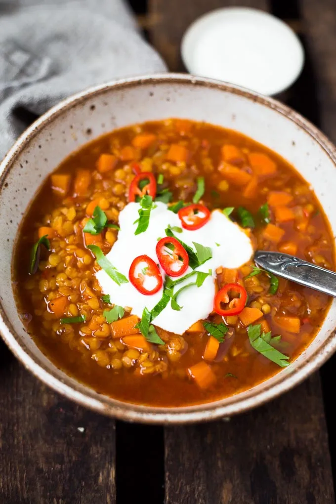 Eine Schüssel rote Linsensuppe mit einem Klecks Joghurt und frischem Chili