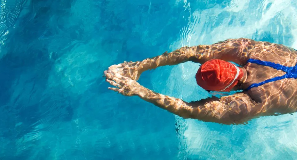 Eine Schwimmerin unter Wasser, von der Seite gefilmt, die Technik analysiert.