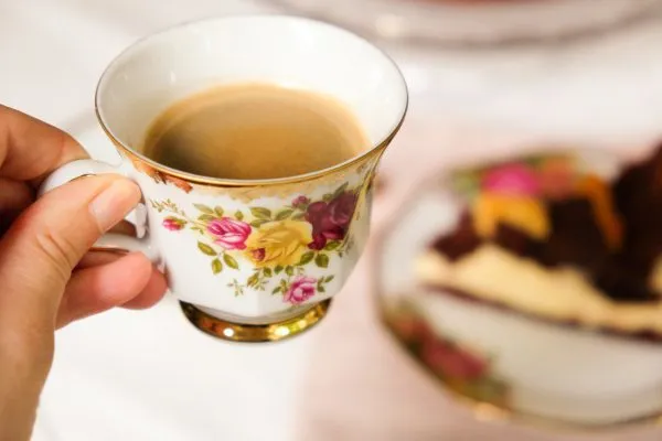 Eine Tasse Kaffee neben einem Stück Russischem Zupfkuchen, ideal für die Nachmittagskaffeetafel