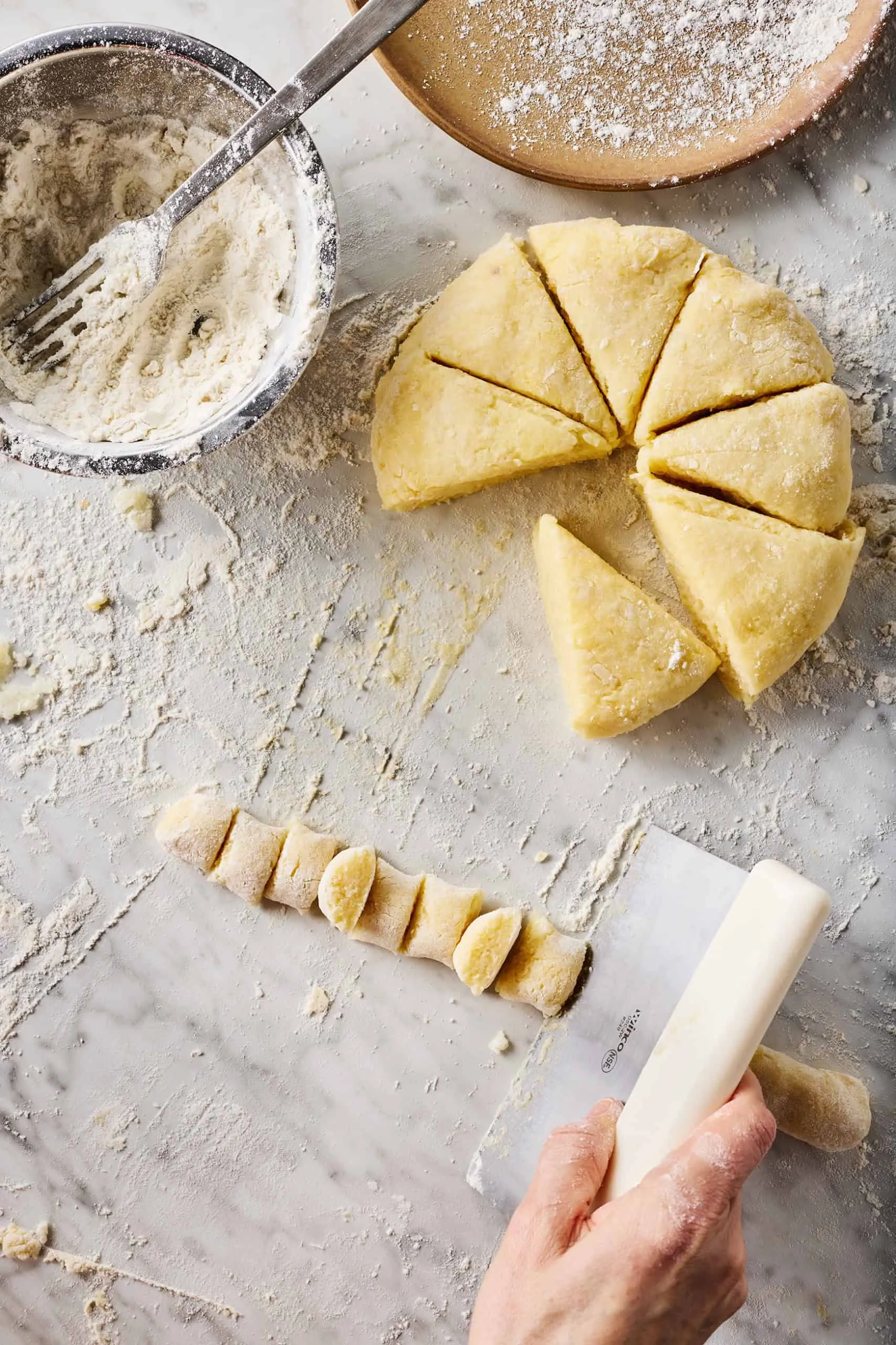 Eine Teigrolle wird in kleine Gnocchi-Stücke geschnitten, um die typische Form zu erhalten.