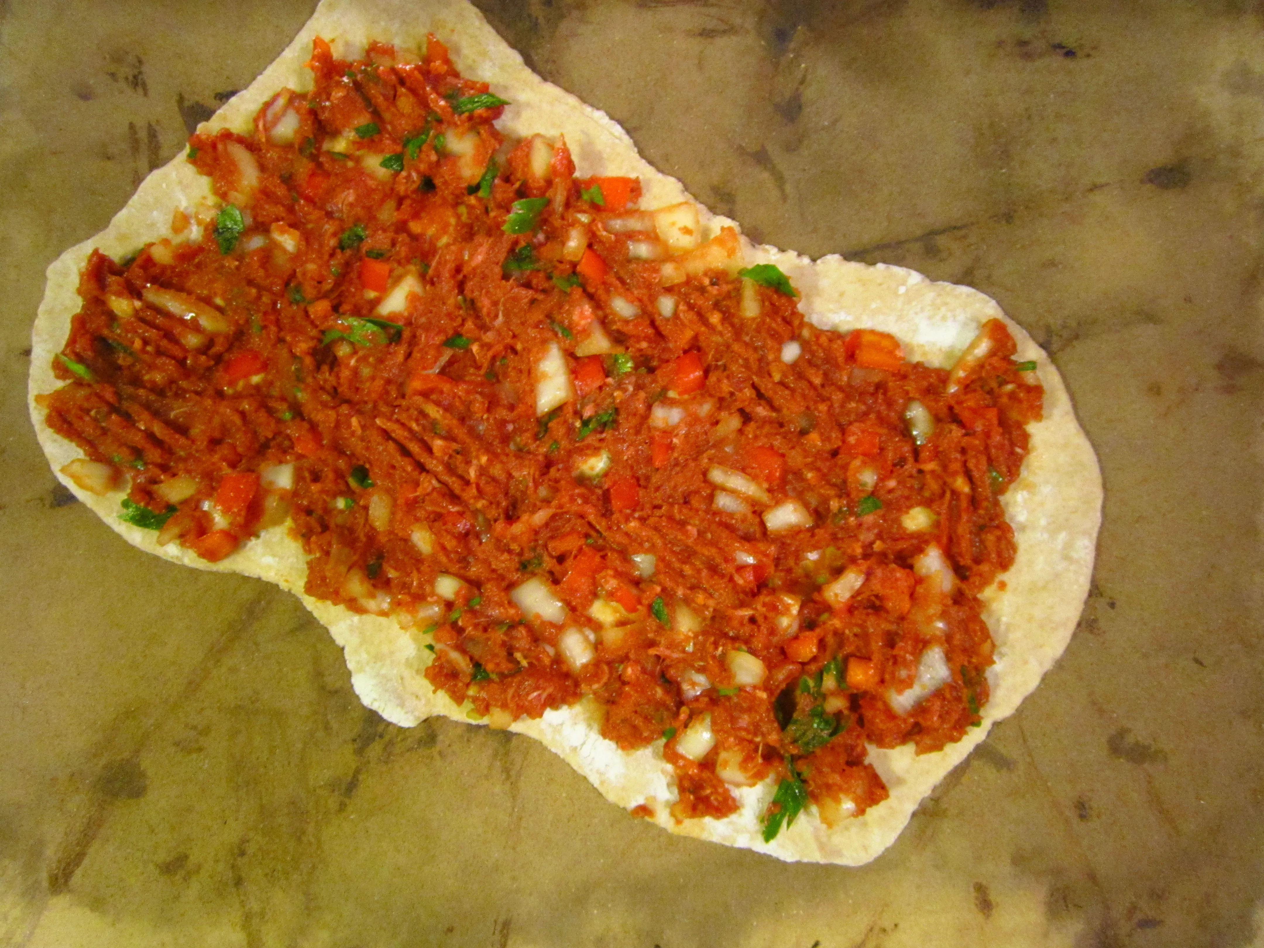 Eine Türkische Pizza auf dem Pizzastein, bereit zum Backen im Ofen