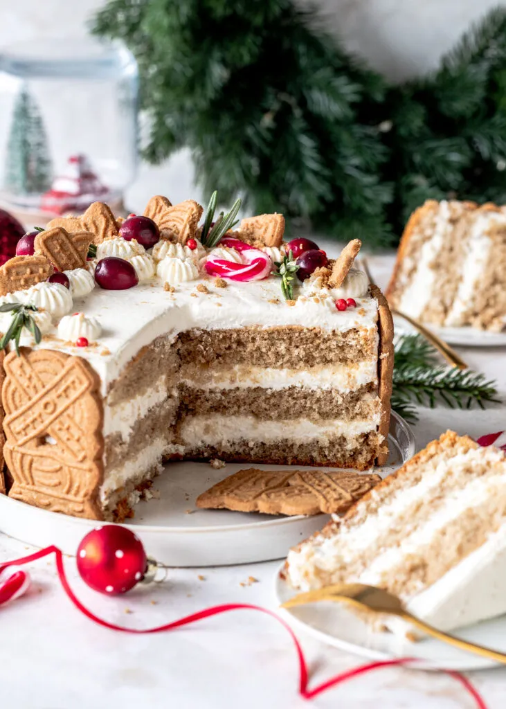 Eine wunderschön dekorierte Spekulatius Torte auf einem festlichen Weihnachtstisch, umgeben von Tannenzweigen und Lichtern.