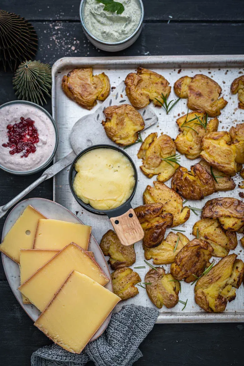 Einladendes Foto eines Raclette-Tisches mit verschiedenen Zutaten und geschmolzenem Käse.