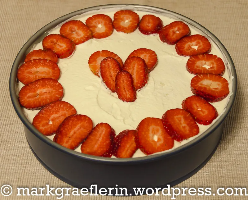 Erdbeer-Sahnetorte mit frischen Erdbeeren, fertig zum Servieren auf einer Tortenplatte.