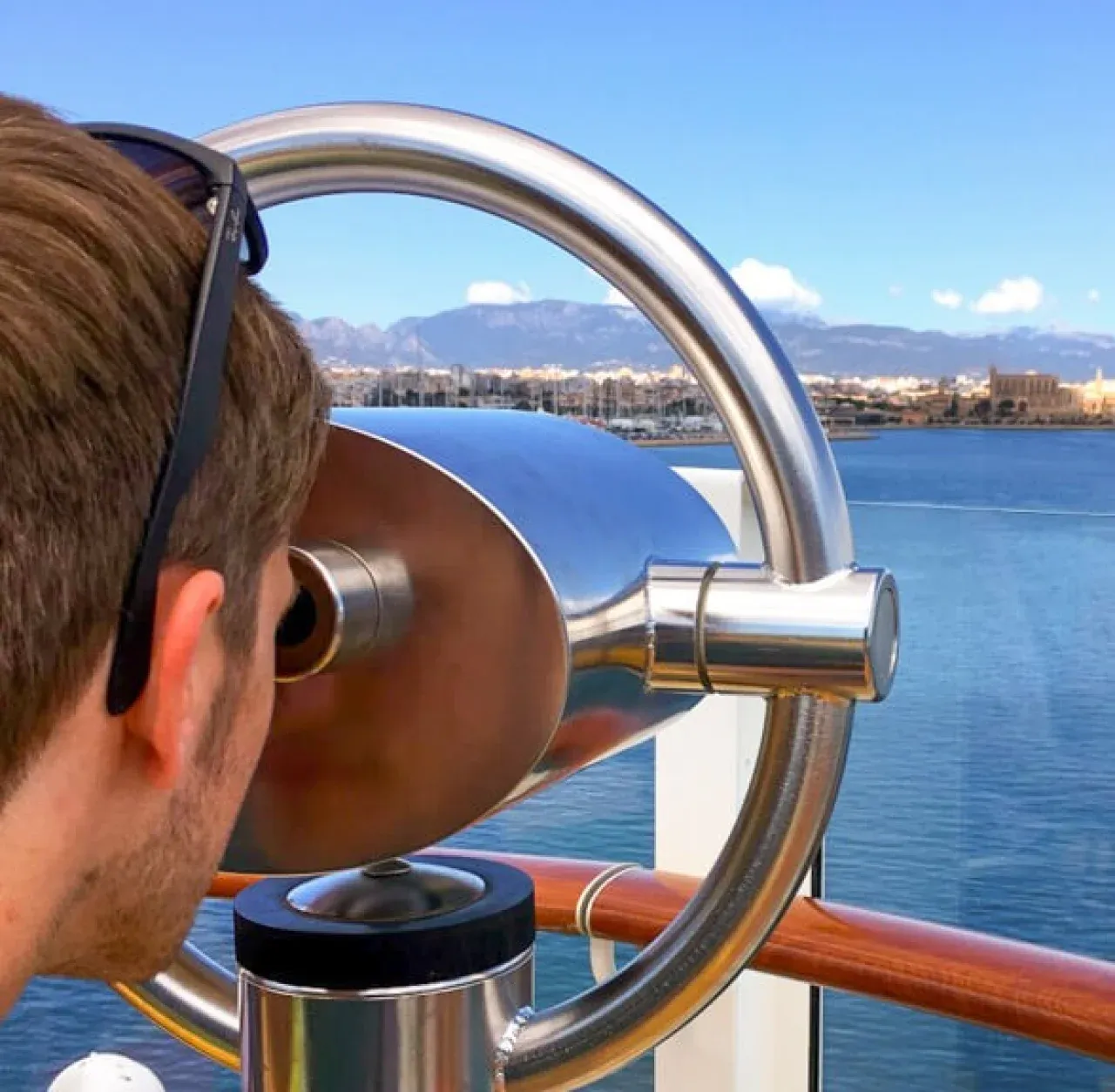 EURESAreisen Kollege Tobias schaut durch Fernrohr von Kreuzfahrtschiff auf Palma de Mallorca