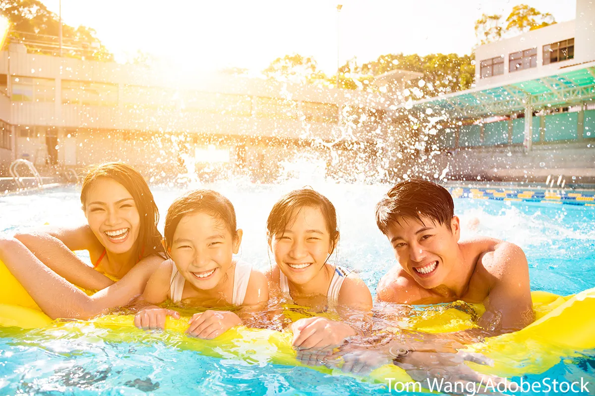 Familie genießt das Schwimmen im Freibad – idealer Sport für Anfänger und Jung & Alt