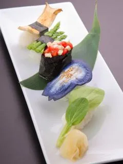 Farbenfrohes vegetarisches Sushi mit Blattsprossen, Aubergine und roten Paprikawürfeln