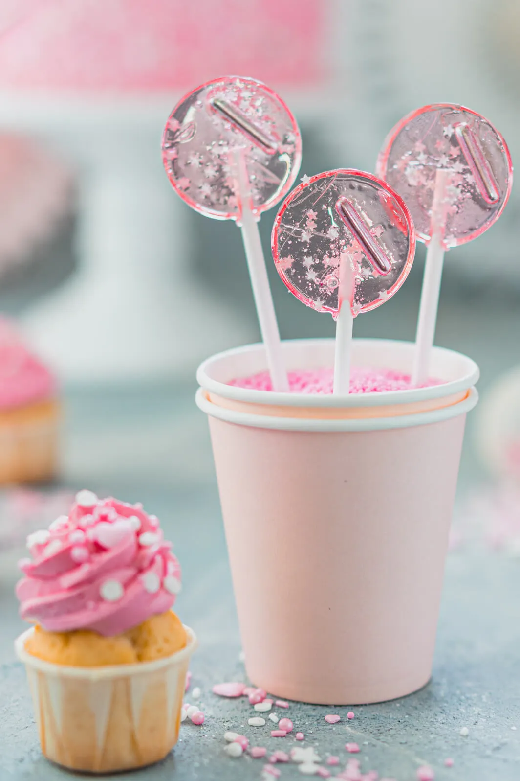 Feierlicher Geburtstagstisch mit rosa Himbeer-Torte, Kerzen und Süßigkeiten
