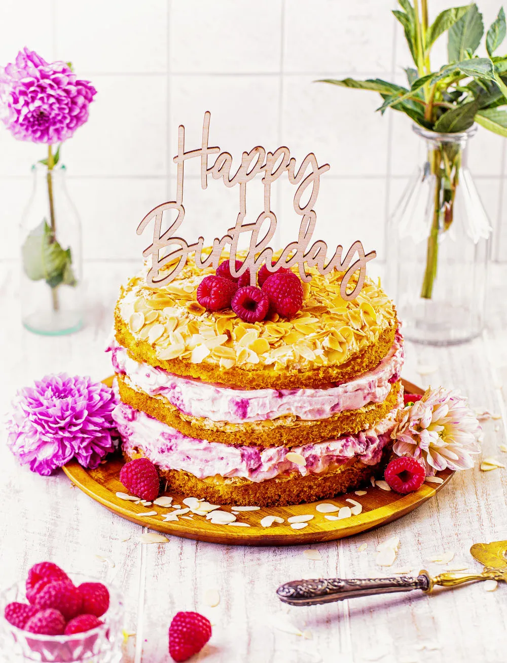 Feierlicher Himbeer-Quark Naked Cake auf einem Tortenständer, bereit zum Servieren