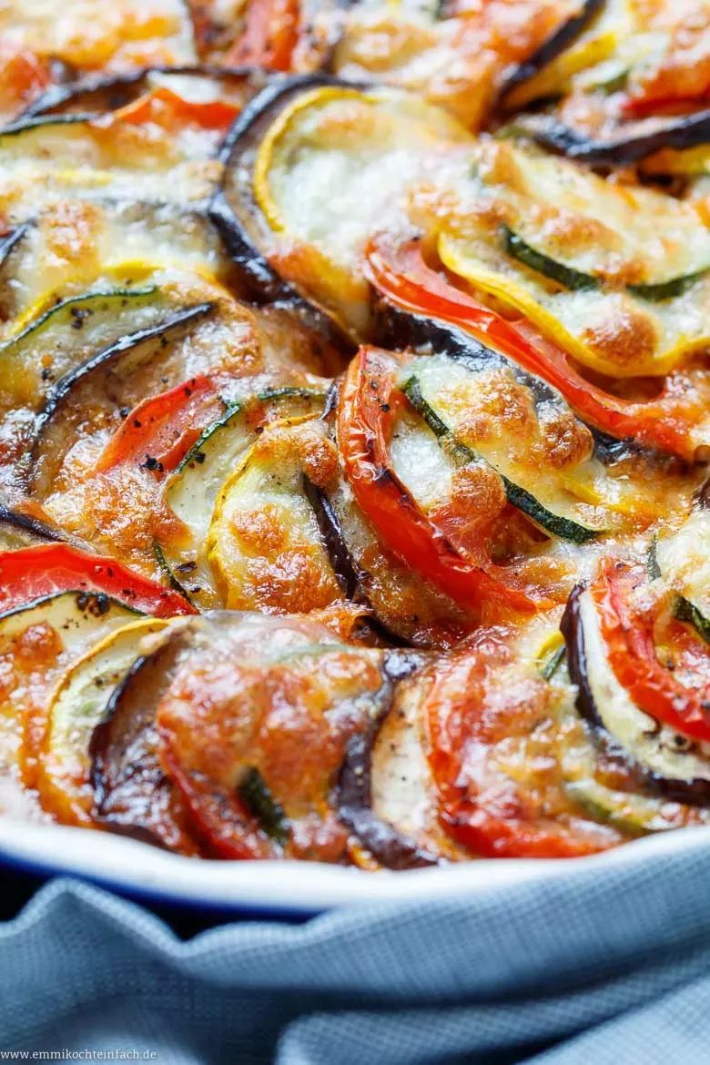 Fein gehackte Schalotten und Knoblauch in einer Pfanne, die Basis für die aromatische Soße des Zucchini-Auberginen-Auflaufs.