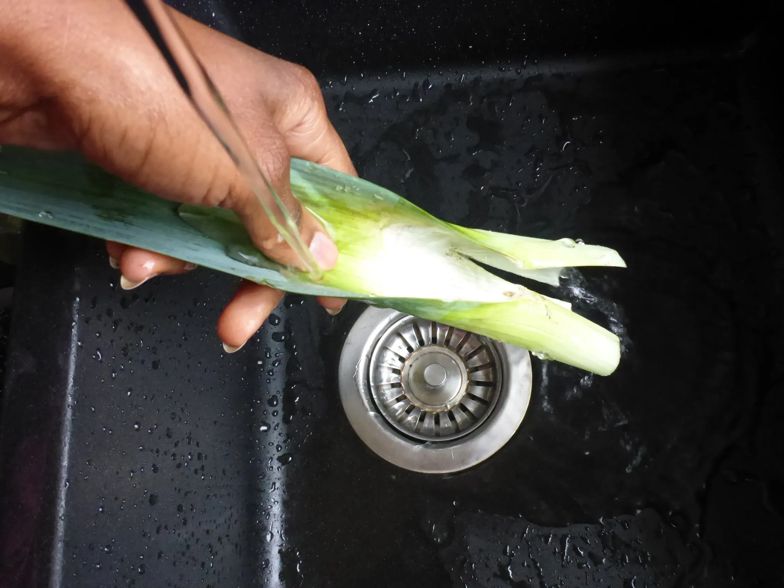 Fein geschnittene weiße und hellgrüne Lauchringe auf einem Schneidebrett, bereit, der cremigen Lauch-Pilz-Sauce für die Schnitzelpfanne Geschmack zu verleihen.