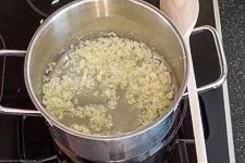 Fein gewürfelte Zwiebeln und Knoblauch werden in Butterschmalz angedünstet