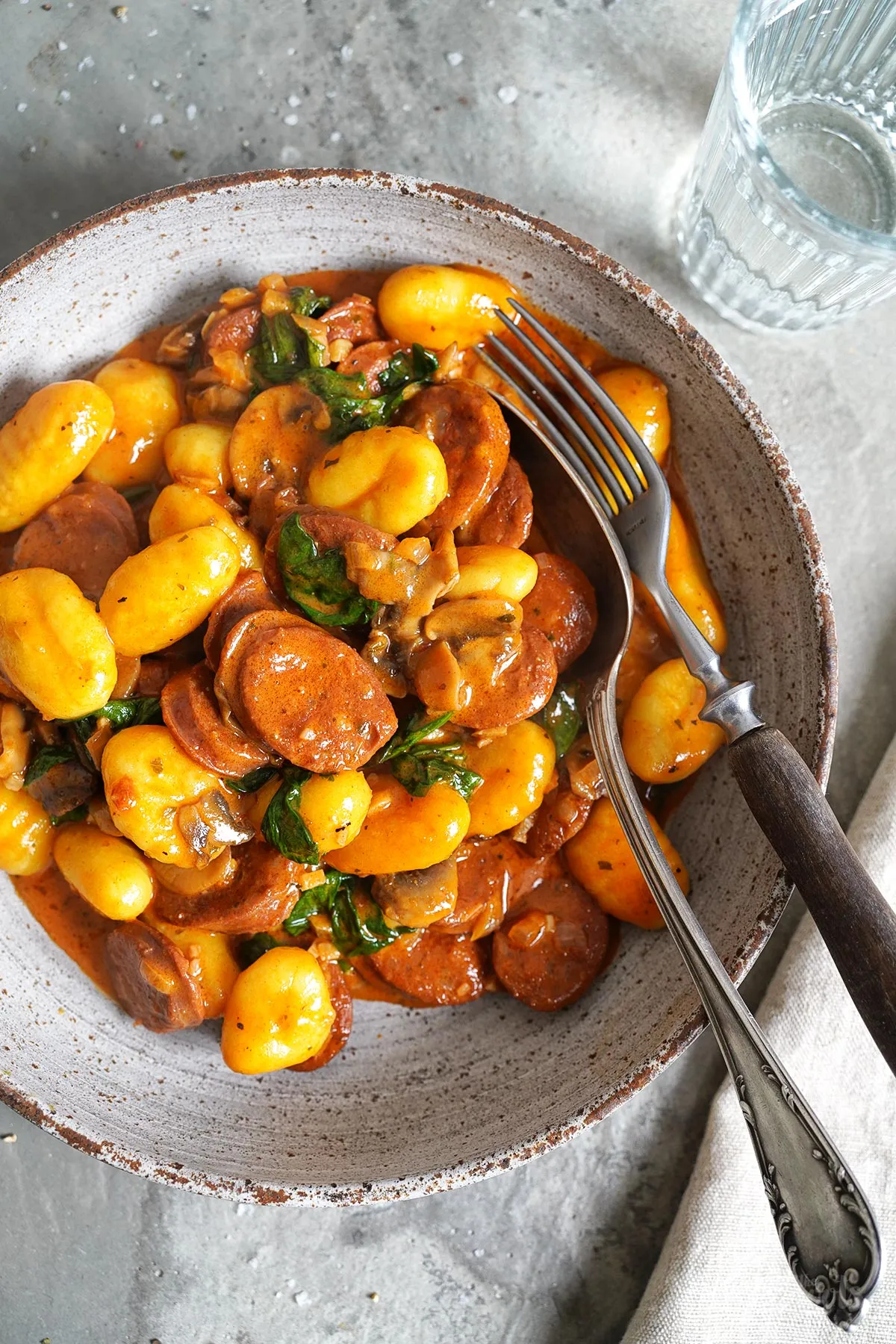 Fertig angerichtete Gnocchi mit Spinat, Pilzen und Chorizo in einer tiefen Schale