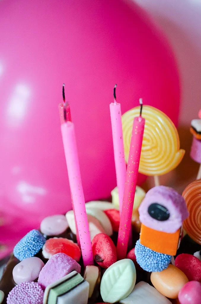 Fertig dekorierter Candy Cake mit einer Fülle von Süßigkeiten, Geburtstagskerzen und Wunderkerzen