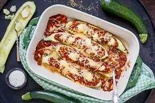 Fertig gebackene gefüllte Zucchini Schiffchen mit geschmolzenem Käse