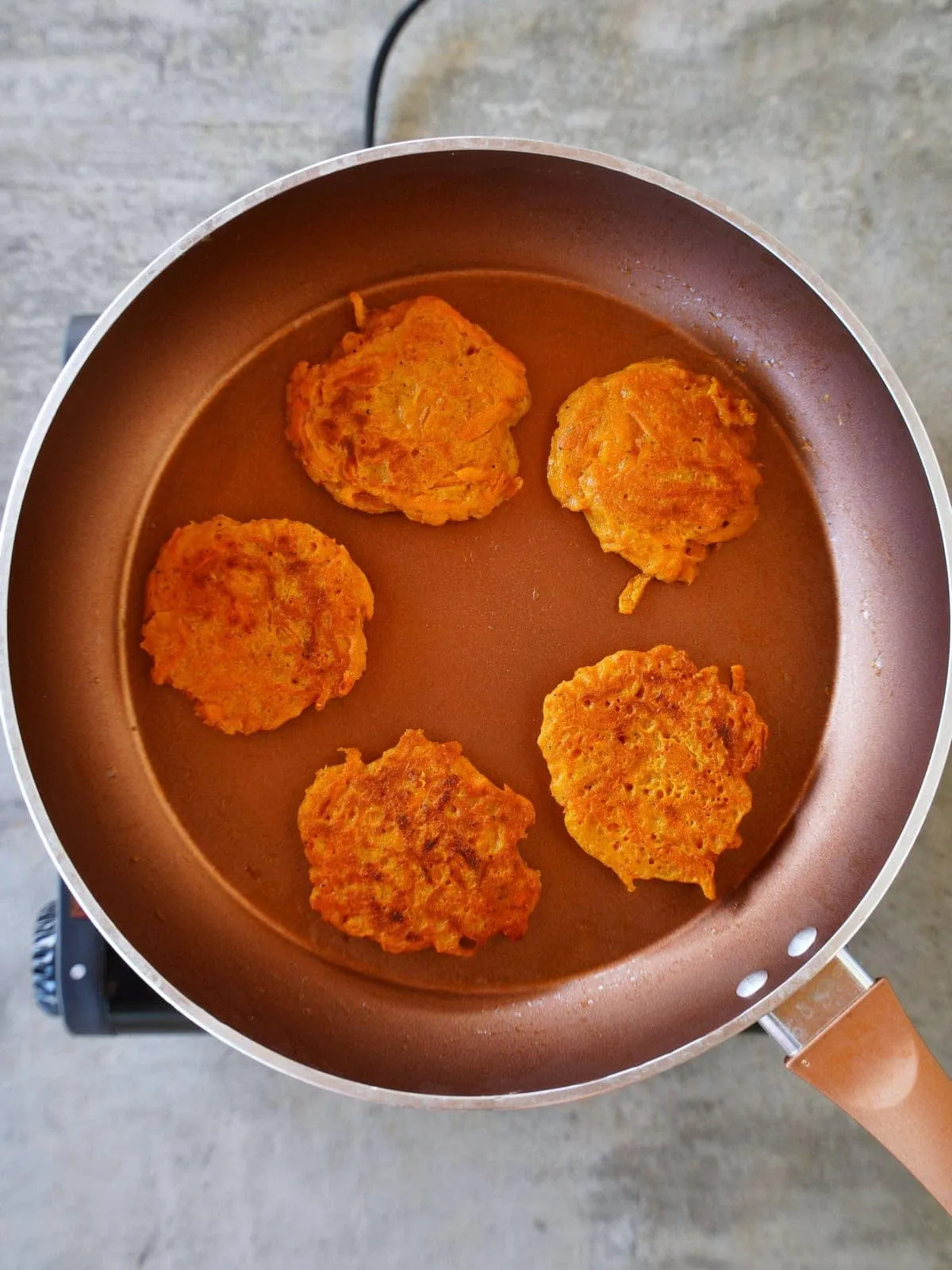 Fertig gebratene Karotten-Patties in der Pfanne, knusprig und lecker