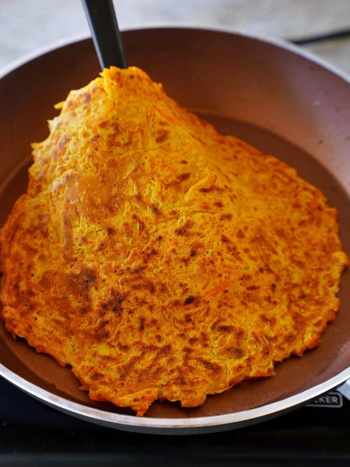 Fertig gebratenes Karotten-Omelett auf einer Holzplatte, eine tolle Mahlzeit