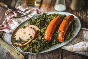 Fertig gekochter Grünkohl mit Wurst und Kassler auf einem Teller