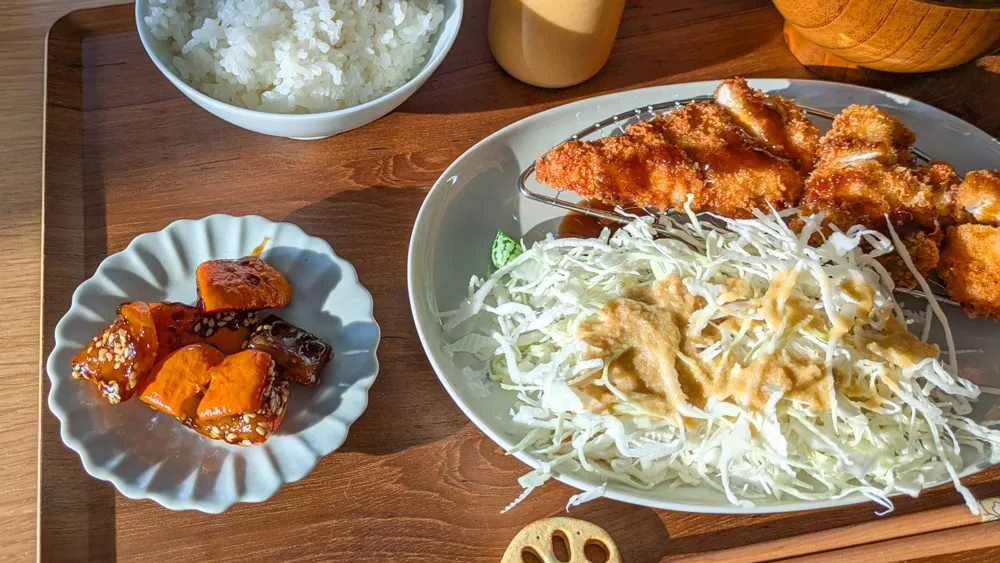 Fertig zubereitetes Kabocha Nanban als Teil eines japanischen Menüs mit Beilagen.