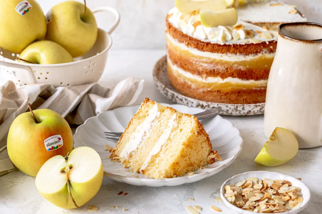 Fertige Apfelmus-Torte mit Sahnetupfen und Apfelstückchen als Dekoration