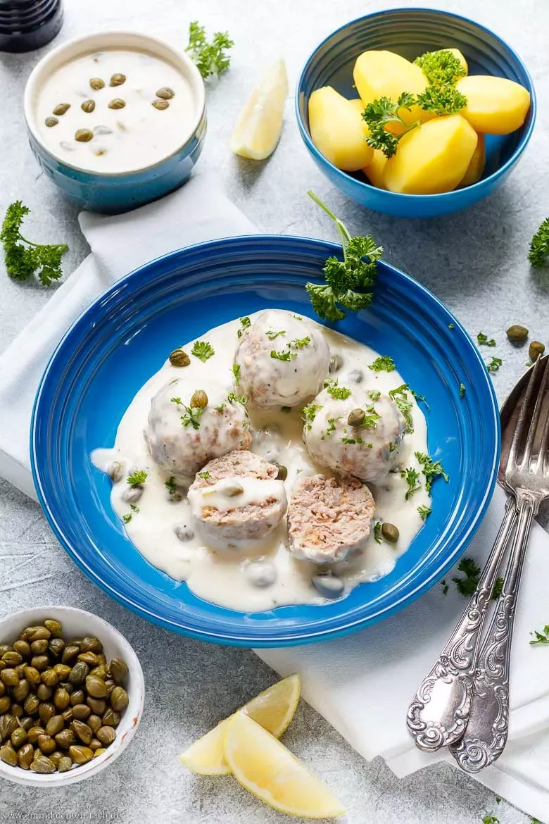 Fertige Königsberger Klopse mit Salzkartoffeln in cremiger Kapernsoße