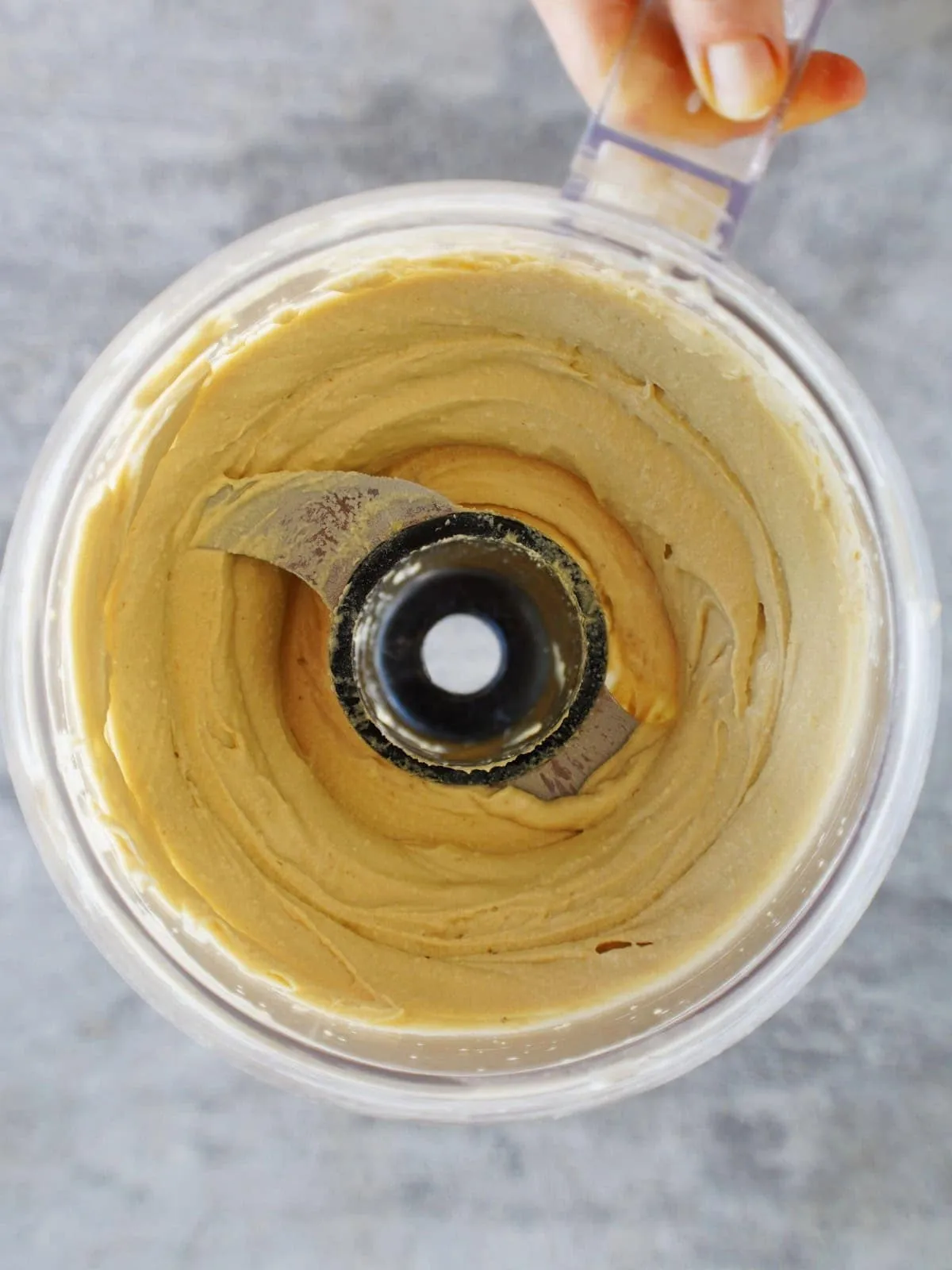 Fertiger cremiger Kichererbsen-Dip in der Küchenmaschine, bereit zum Abschmecken und Servieren