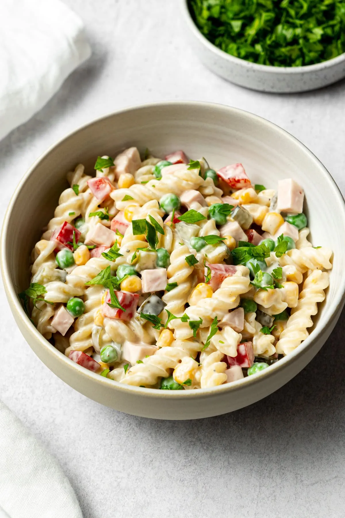 fertiger deutscher Nudelsalat mit gehackter Petersilie in einer Servierschüssel