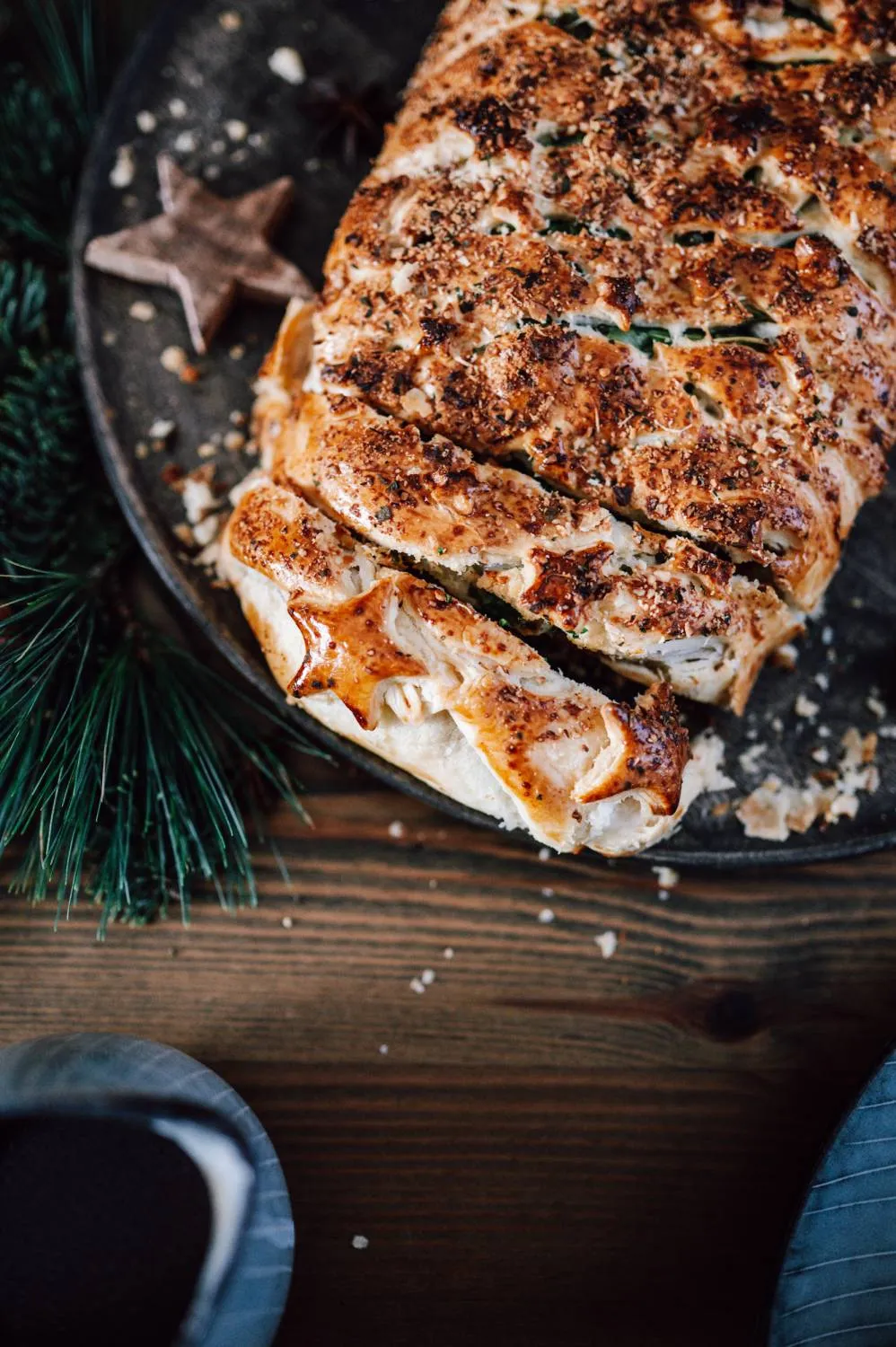 Festlich angerichteter vegetarischer Weihnachtsbraten im Blätterteigmantel mit knuspriger Kruste und Kräutern