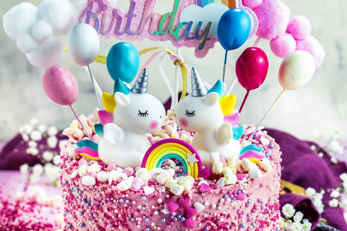 Festlich dekorierte Einhorn-Geburtstagstorte auf einem rosafarbenen Teller, ideal für einen Kindergeburtstag