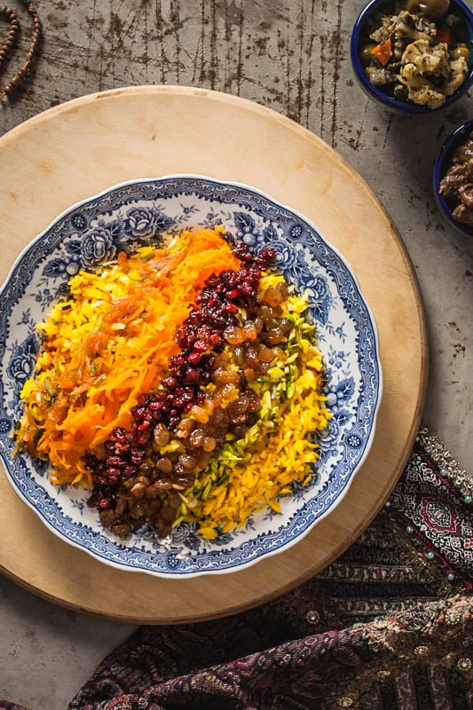 Festlich dekorierter Morassa Polo Reis mit Nüssen, getrockneten Früchten und Orangenstreifen