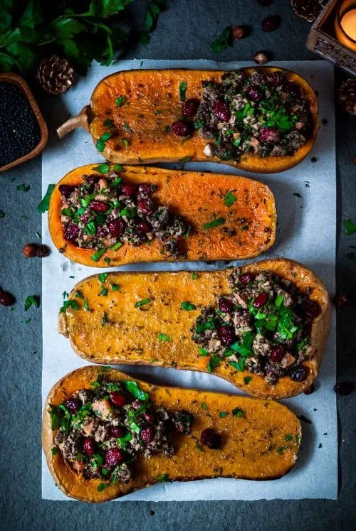 Festlicher gefüllter Kürbis mit Belugalinsen und Preiselbeeren, angerichtet als vegetarisches Weihnachtsgericht
