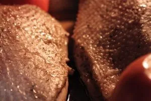 Fett läuft langsam aus der Gänsebrust während des Niedertemperatur-Garens