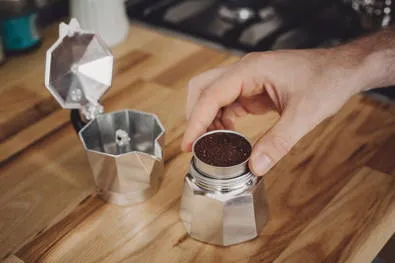 Filter mit Kaffeepulver wird in den Espressokocher eingesetzt und die Kanne verschlossen