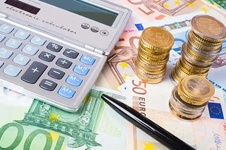 Finanzielle Planung mit Kapitallebensversicherung: Geldscheine und ein Taschenrechner symbolisieren die Berechnung von Beiträgen und Steuervorteilen, die über einen Vergleichsportal wie Check24 ermittelt werden können.