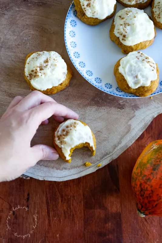 Flache Kürbis-Cookies mit Frischkäse-Frosting auf Backpapier