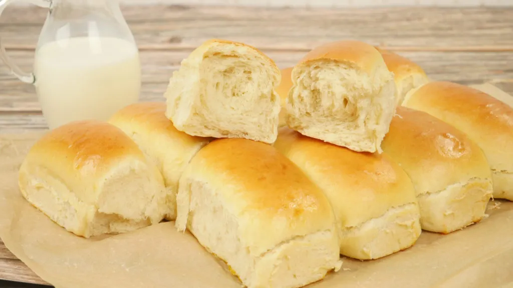 Fluffige, goldbraun gebackene Abreißbrötchen frisch aus dem Ofen auf einem Backblech.