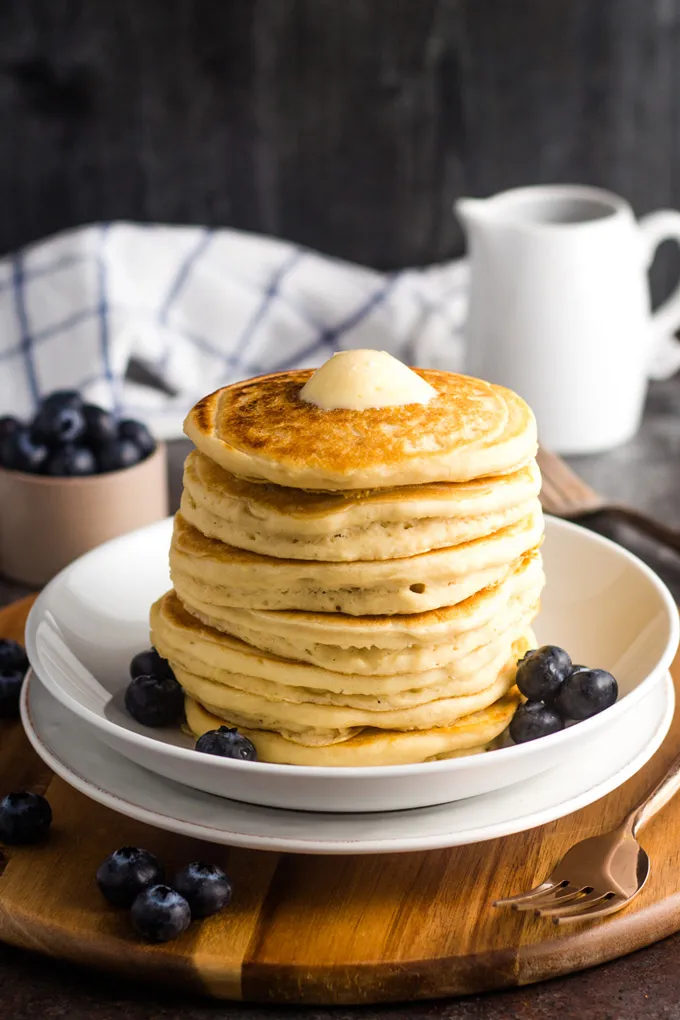 Fluffige vegane Pancakes mit Butterklecks und Heidelbeeren