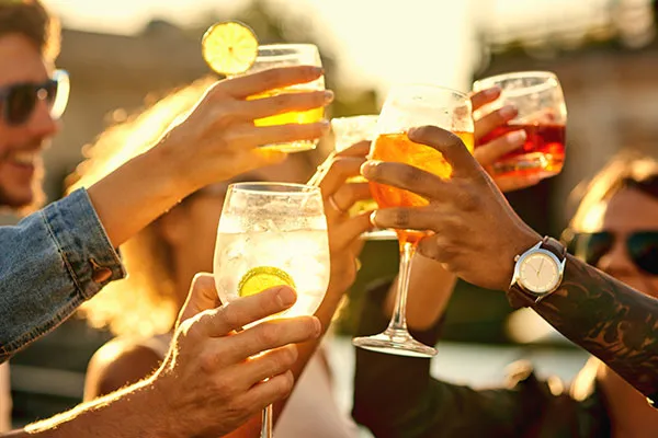 Freunde stoßen mit Gläsern an, symbolisch für geselliges Beisammensein und die deutsche Trinkkultur bei Festlichkeiten.