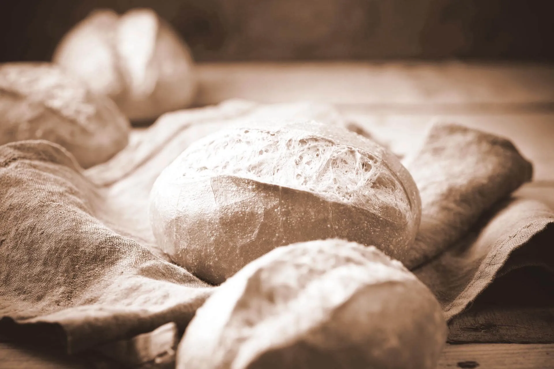 Frisch gebackene Brötchen auf einem rustikalen Tuch.
