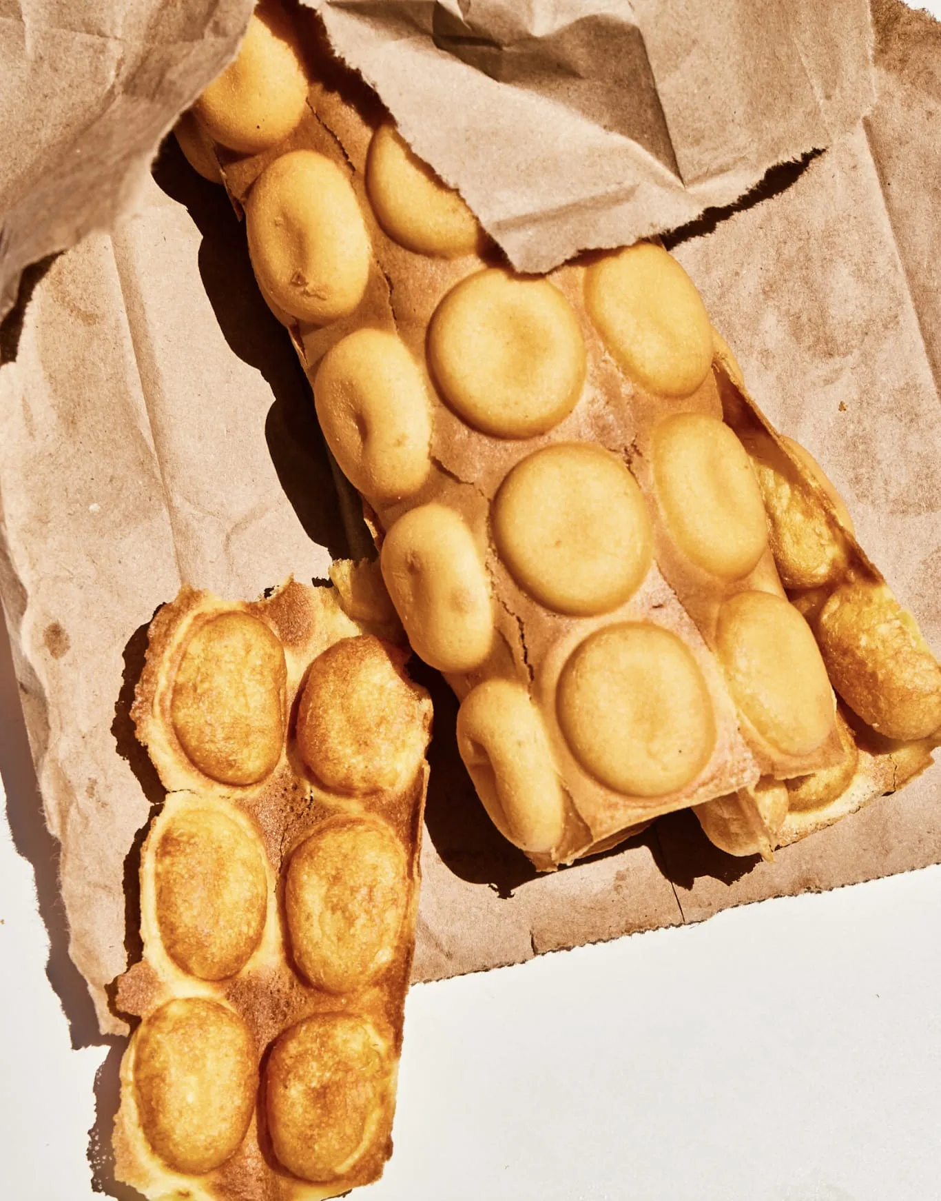 Frisch gebackene goldbraune Bubble Waffel mit perfekter knuspriger Textur, bereit zum Servieren.