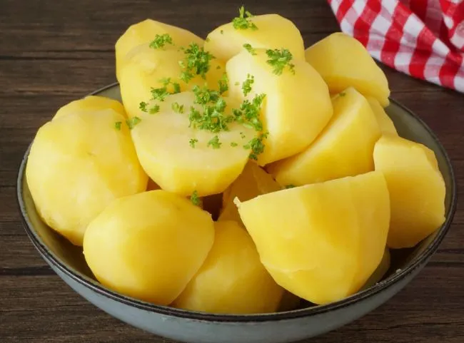 Frisch gekochte Salzkartoffeln, eine beliebte deutsche Beilage, oft serviert mit Karotten.