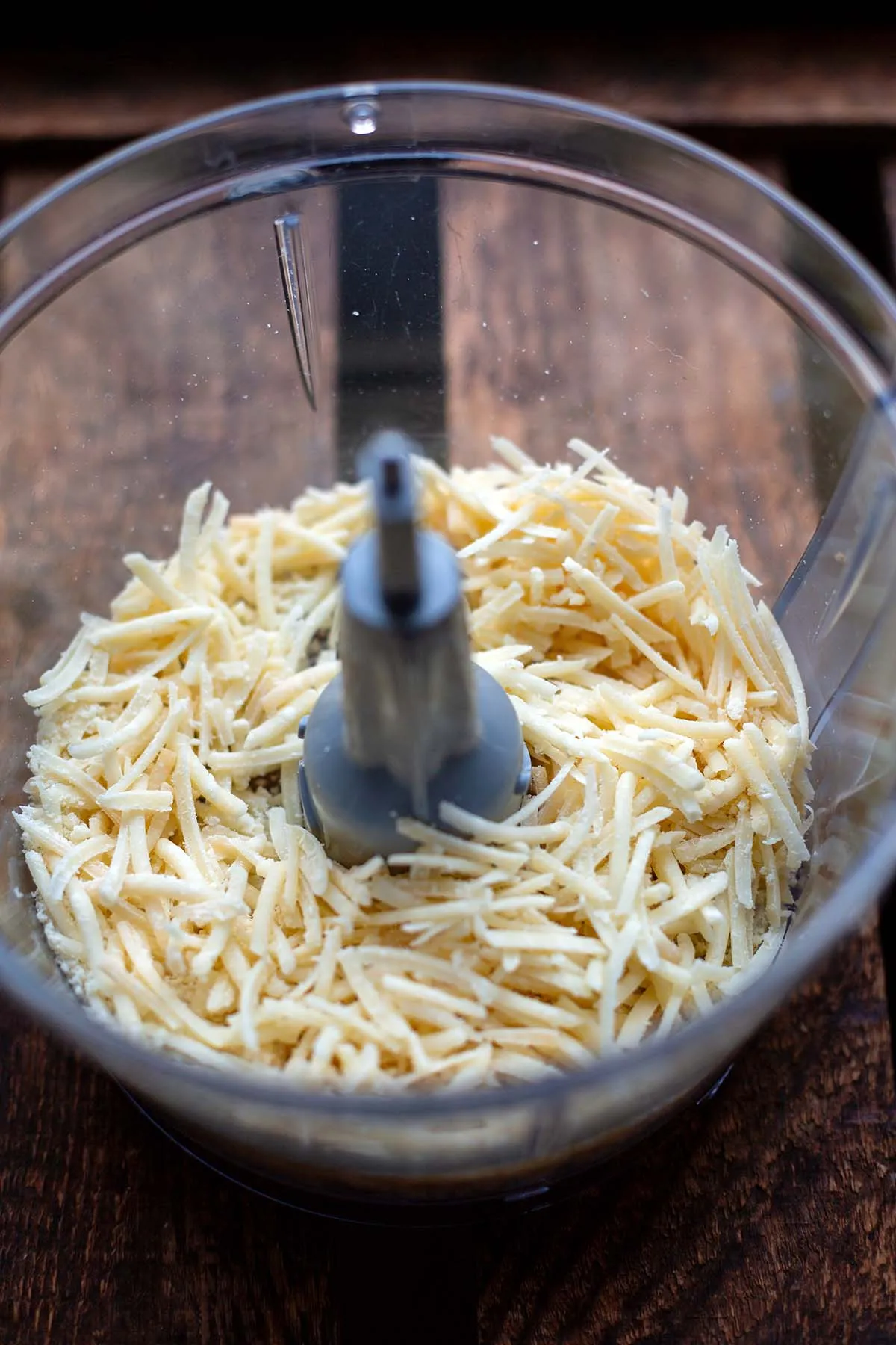 Frisch geriebener Parmesan in einer Küchenmaschine für die cremige Käse-Sahne-Soße.