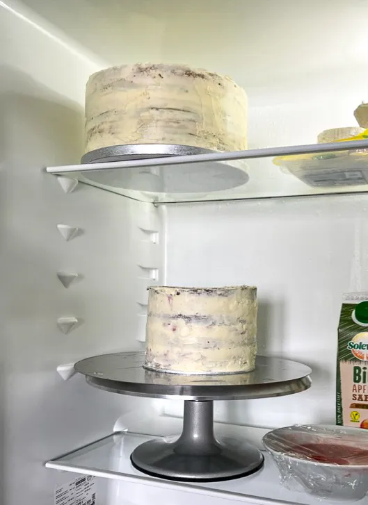 Frisch geschichtete Torte in einem hohen Tortenring mit Tortenrandfolie, bereit zum Kühlen